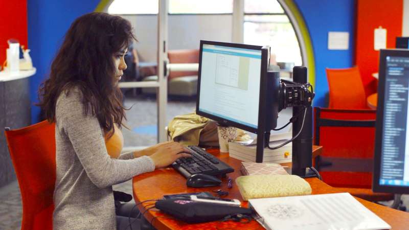 A student is typing at a computer in the Information Technology Entrepreneurial Center