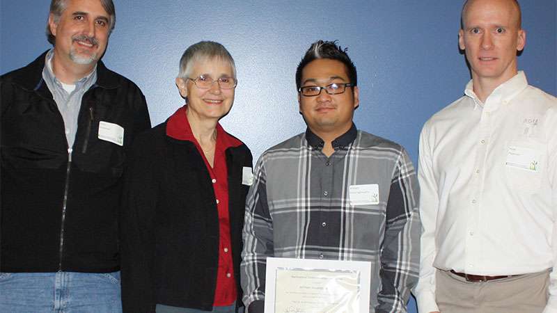 Three donors stand next to a student at the Donors Reception