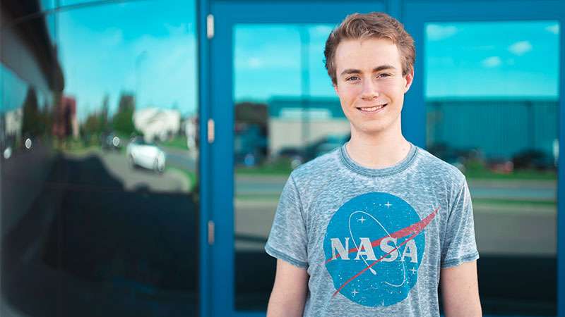 Connor Knezic stands in front of an entrance to the NTC Wausau campus