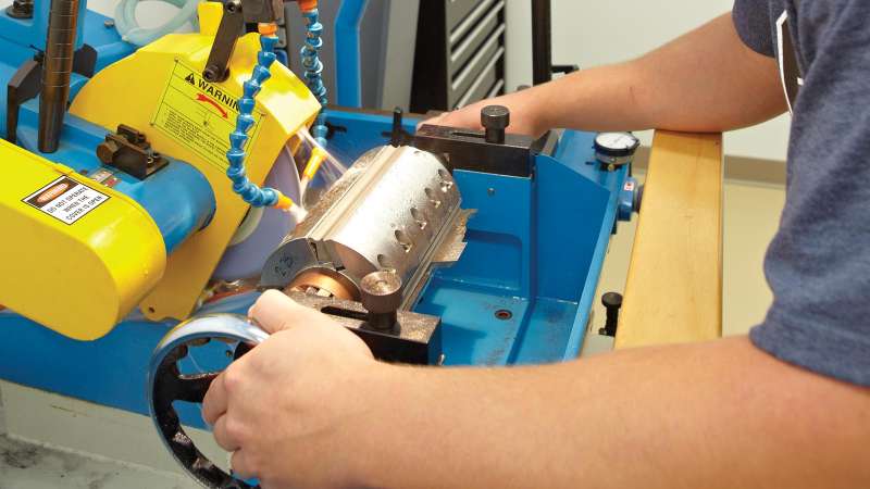 A student works with equipment in a moulder setup and knife grinding workshop.