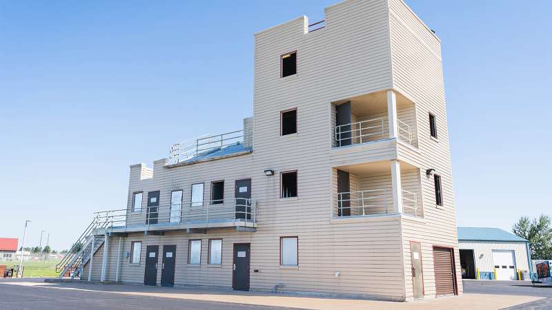 A four story burn tower with many doors, windows, stairs, balconies, and areas that are open and enclosed.