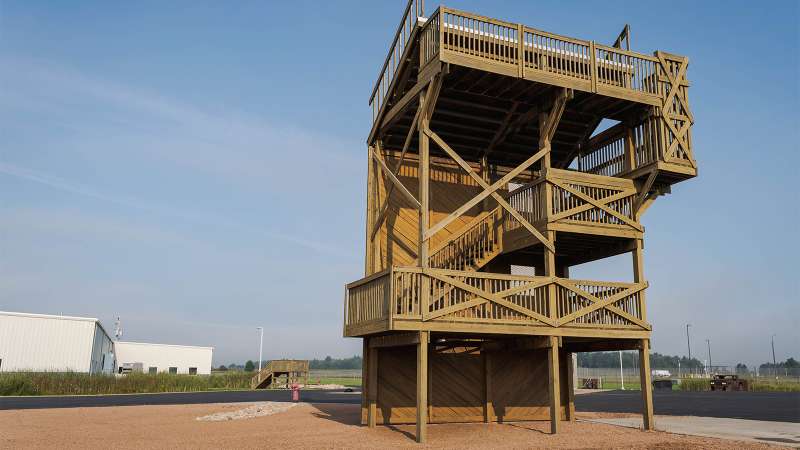 A tall wooden structure with stairs and balconies designed for live fire, confined space, and search and rescue scenarios.