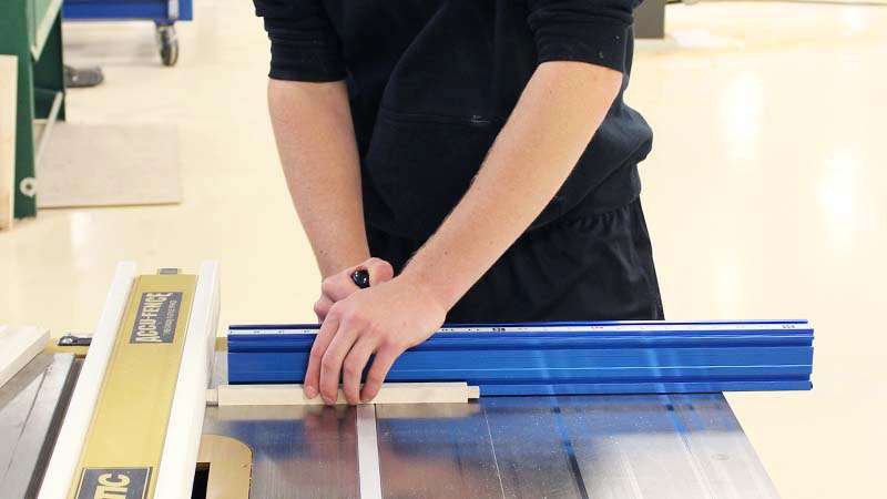 A student machining a tenon using a tablesaw.