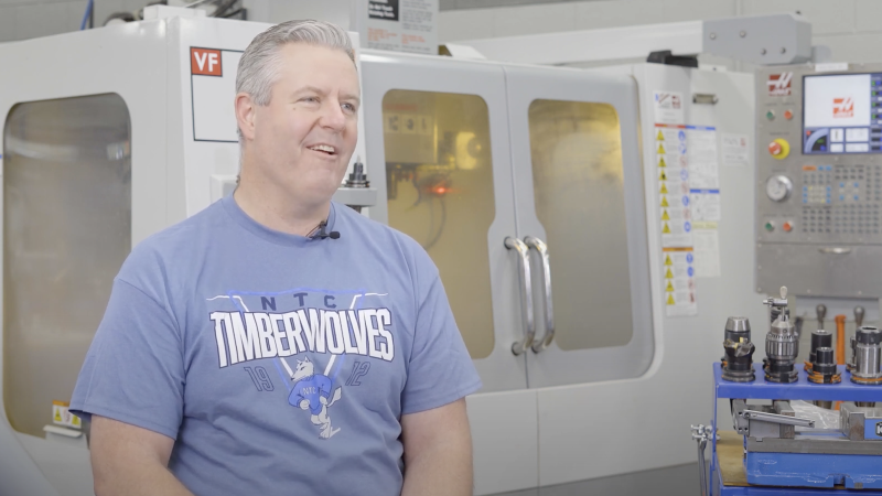 Apprentice John Rupple sitting in front of Tool and Die equipment