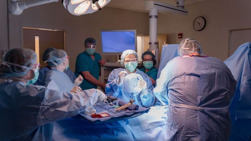 A large group of surgical technology students coordinate a mock operation.