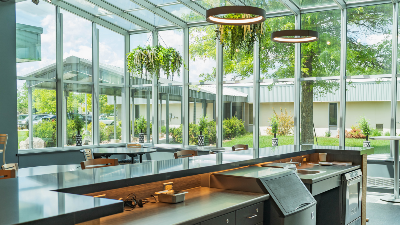 The Spoons Restaurant dining area, encompassed in windows from floor to ceiling, as seen from behind the bar.