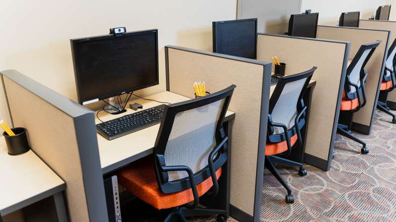 Several testing booths with computers, webcams, and pencils, in the testing room at the NTC Antigo Campus