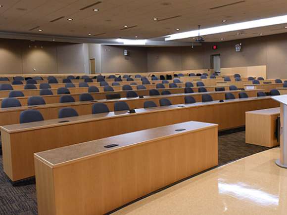 Auditorium with stadium seating and podium, as viewed from the presentation area.