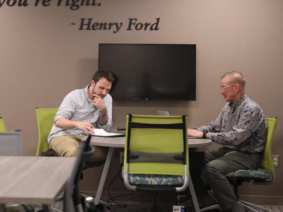 Two businessmen sitting at a table having a discussion.
