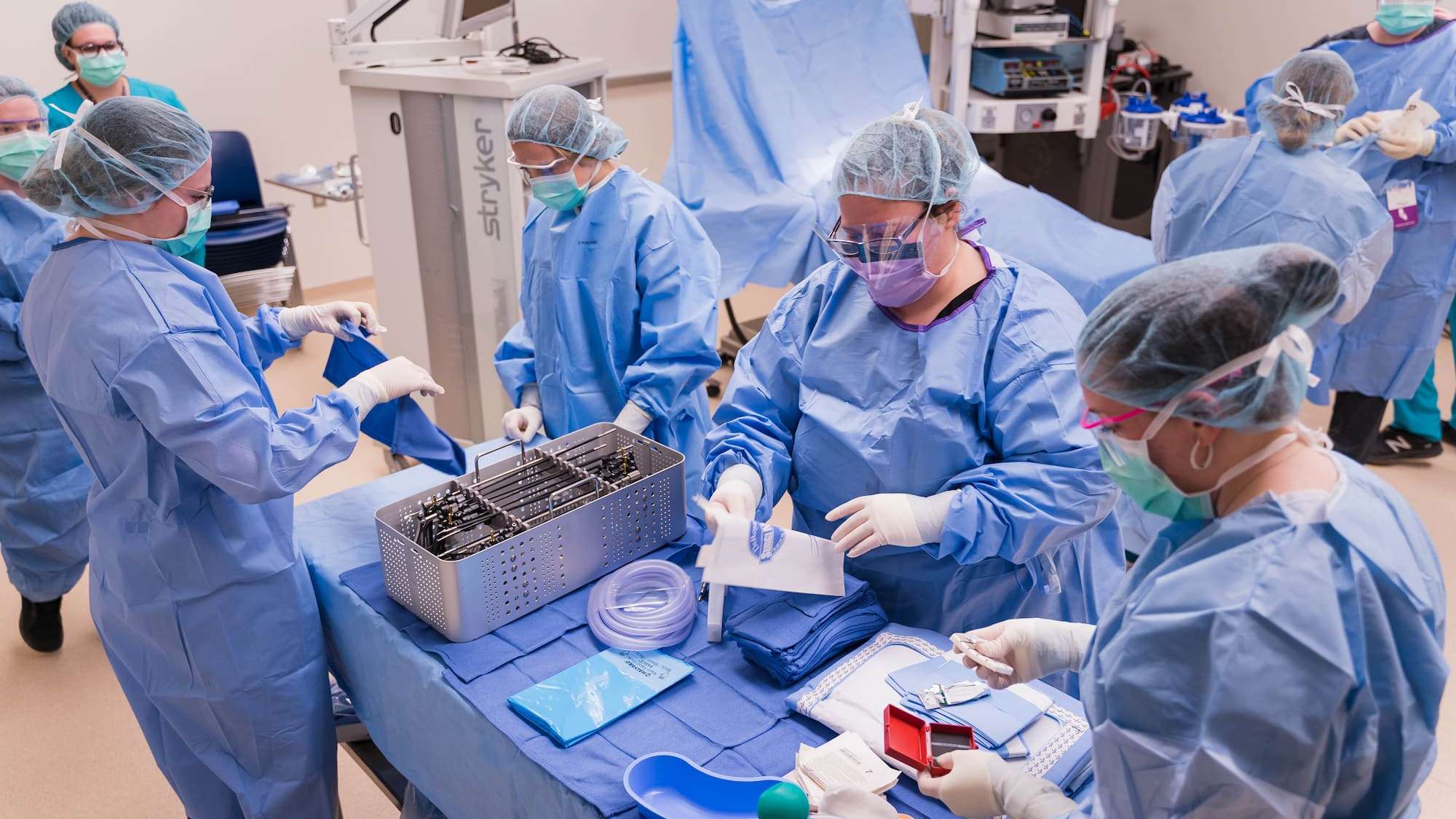 A full team of students prepare and organize surgical tools before a mock operation.