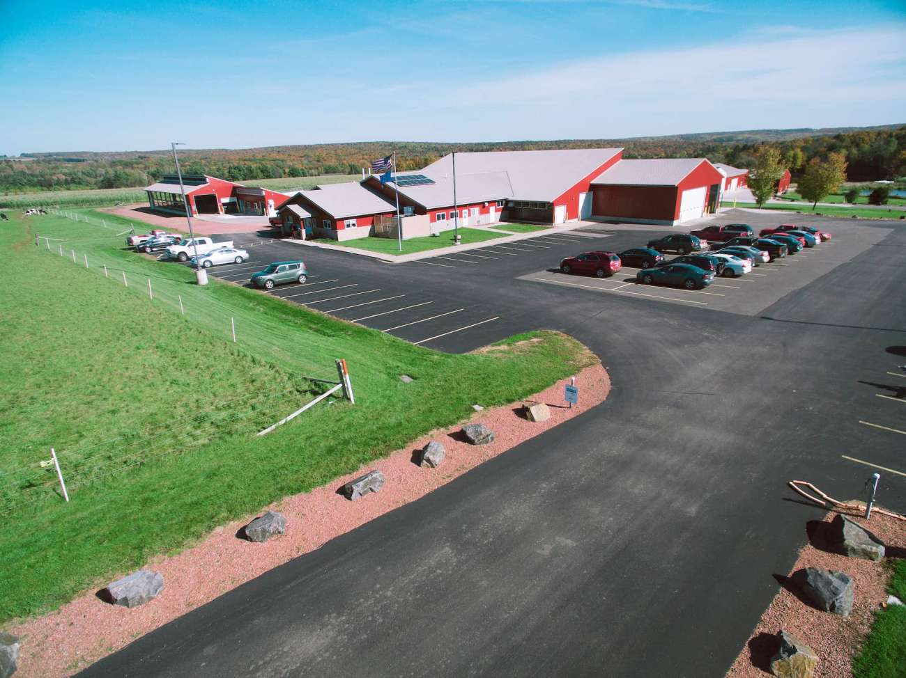 An aerial view of the Agriculture Center of Excellence shows a grazing area for the cows, the pond area, multiple classroom buildings, and the parking lot.