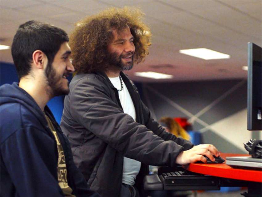 A student is tutoring another student in the Information Technology Entrepreneurial Center (iTEC)