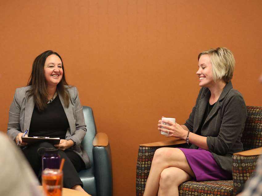 Four businesspeople are in a conference room talking with each other