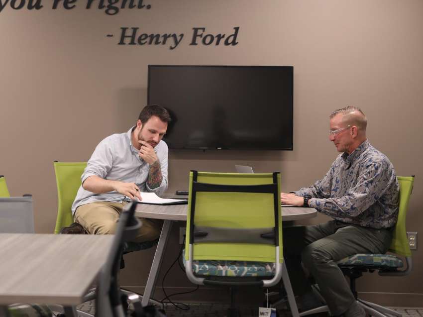 Two businessmen sitting at a table having a discussion.