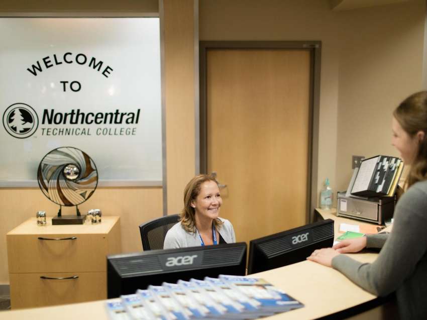 Student talking to a staff member at the front desk of the NTC Wausau Campus.