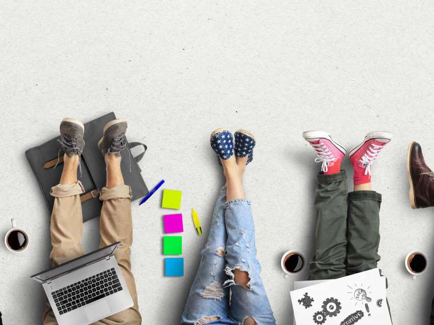 Legs and feet of students studying, with their materials on their laps and coffee mugs next to them.