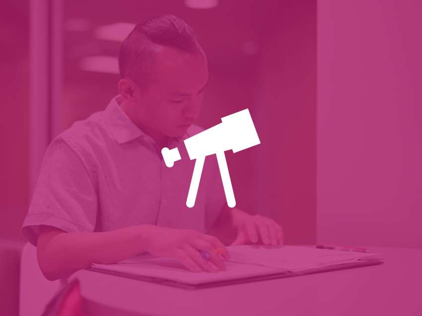 A student reviewing some documents while seated at a table.