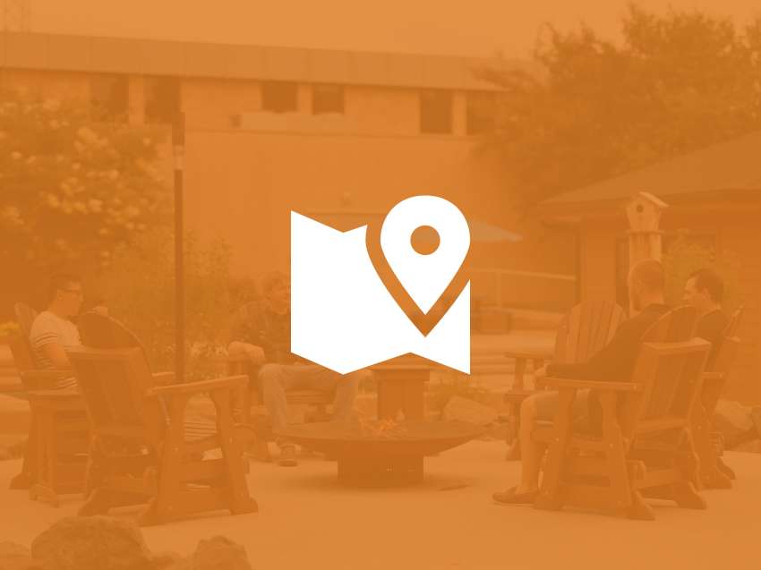 Students sitting around the fire pit in the courtyard of the Wausau Campus.