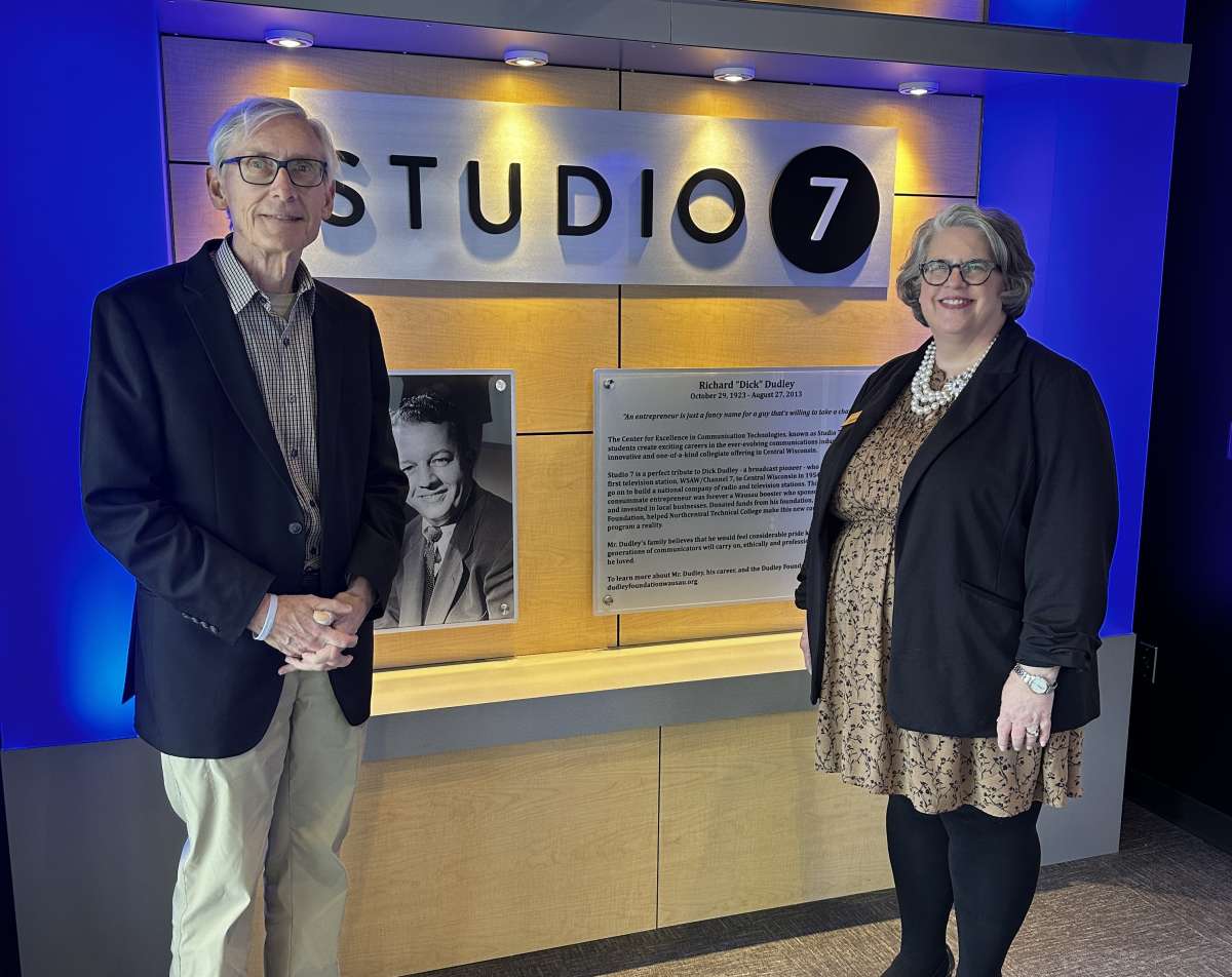 Governor Tony Evers and Dr. Jeannie Worden next to Studio 7 sign