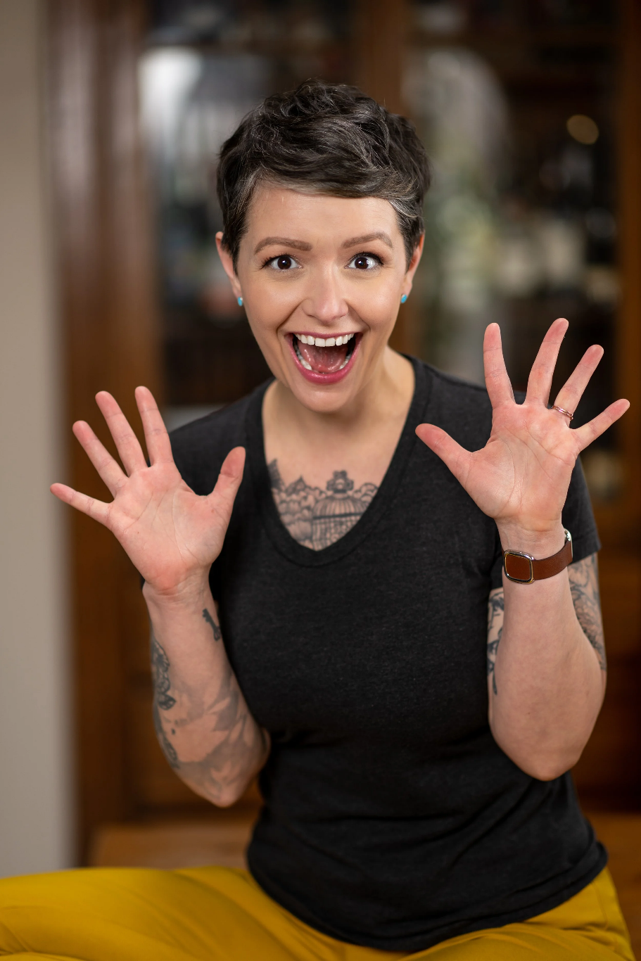 Rachel Giannini, smiling enthusiastically with mouth open and both hands up in front of her