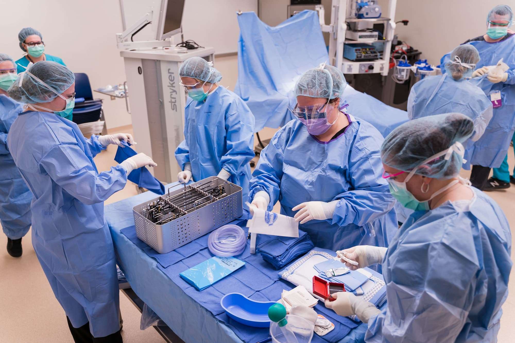A full team of students prepare and organize surgical tools before a mock operation.