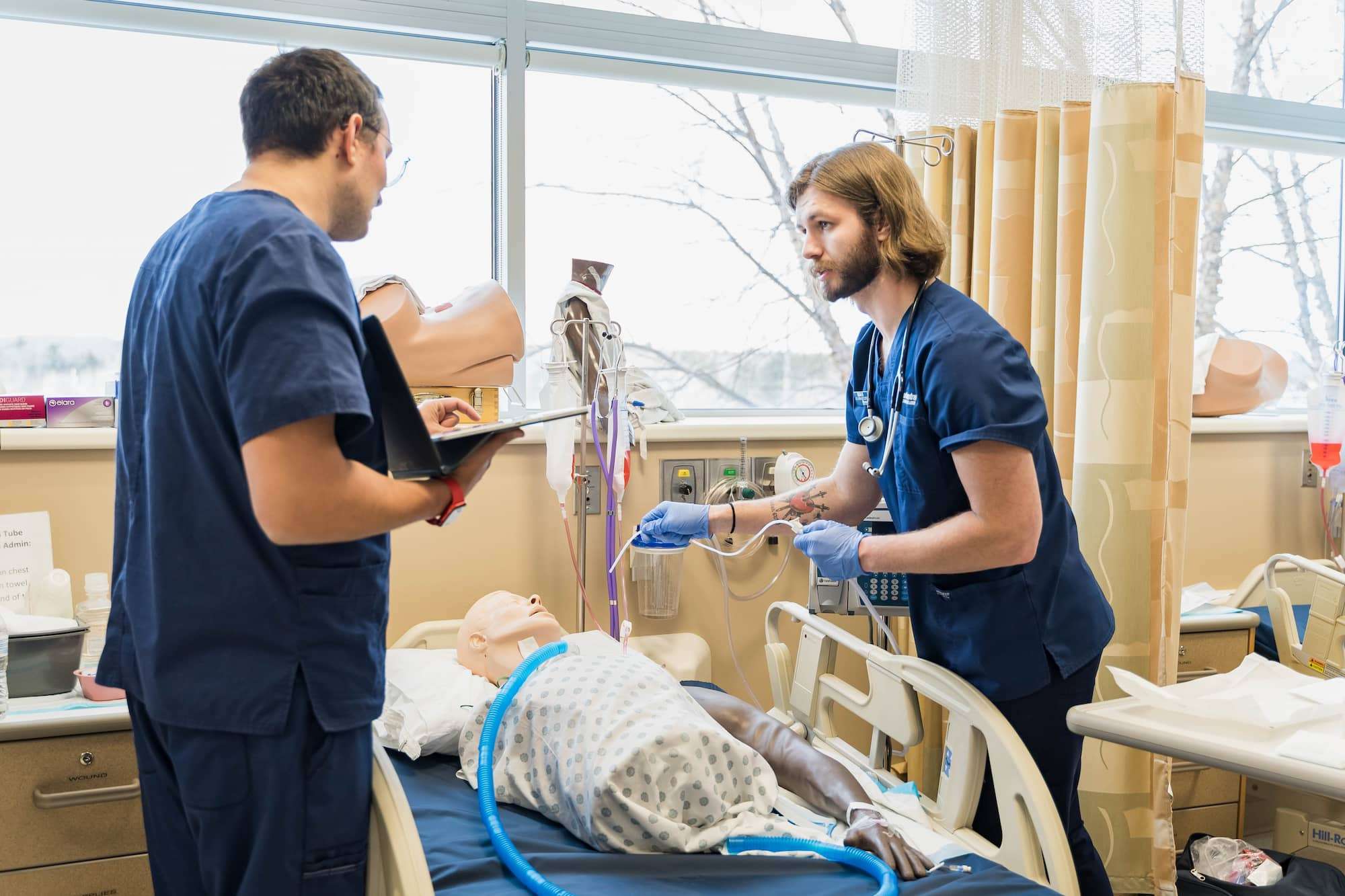 Two students discuss final preparations for their mannequin's oxygenation procedure.