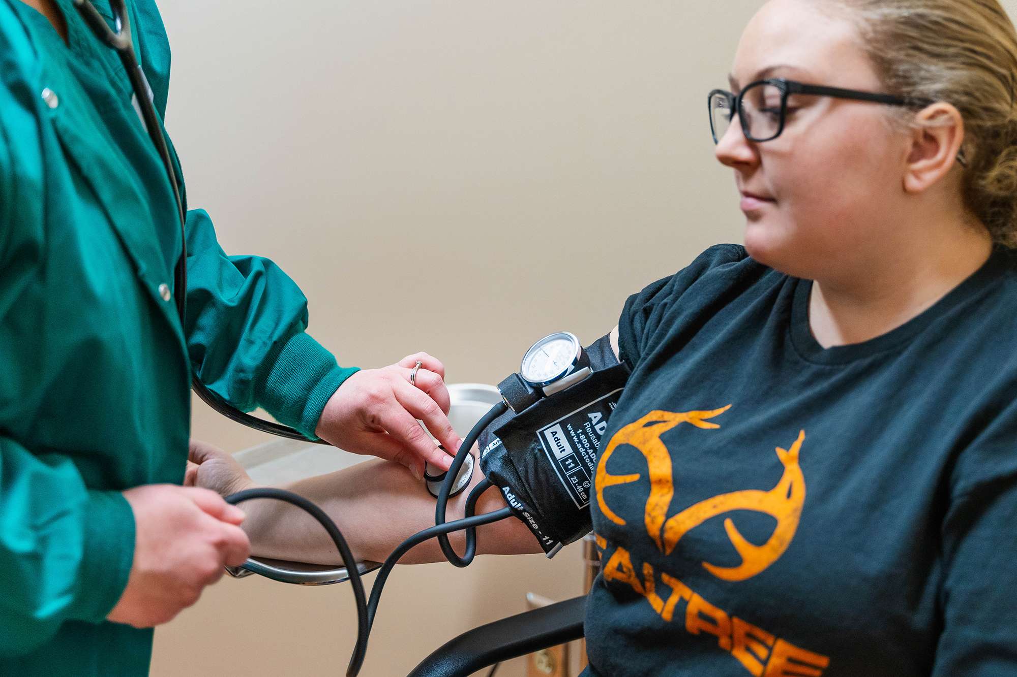 A Medical Assistant is checking the pulse and blood pressure of a patient.