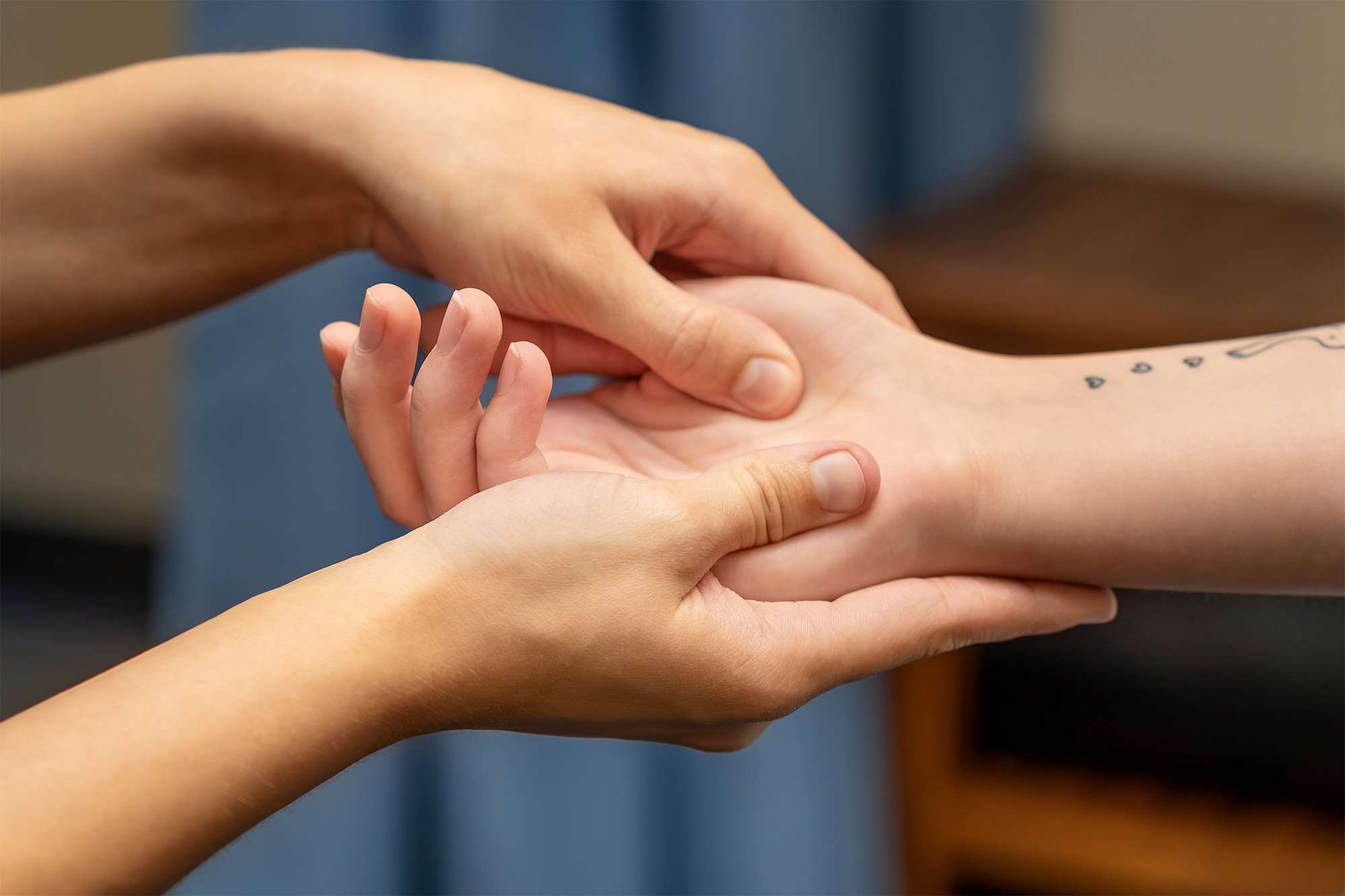 A close up view of a massage therapist massaging a patient's right hand palm.